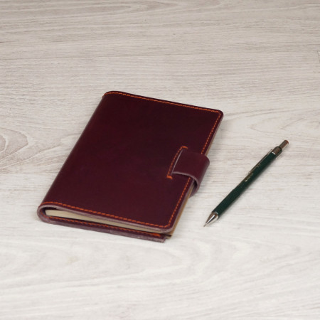 Libreta A6 en color burdeos cosida en naranja